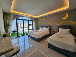a bedroom with two beds and a moon and stars on the wall at Ipoh Young Villa - Hotel Inspired in Ipoh