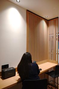 une femme assise sur une chaise dans une pièce dans l'établissement Pavillon de Montmartre, à Paris