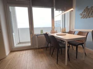 a dining room with a table and chairs and windows at Ostseeliebe M-5-6 in Heiligenhafen