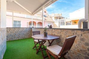 a table and chairs on a balcony with green grass at La Cala Beach by ELE Apartments in Cala del Moral