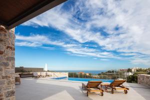 a view of the ocean from the balcony of a house at Oinolithos Luxury Villas in Kalamaki Chanion