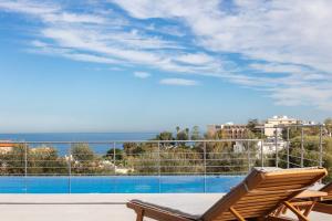 a balcony with a view of a swimming pool at Oinolithos Luxury Villas in Kalamaki