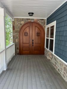 een houten deur op een huis met een veranda bij House #41 Moonset Vista House (Pet Friendly) in Centre