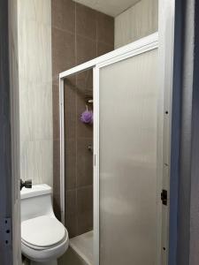 a bathroom with a toilet and a glass shower door at Casa vacacional en Manzanillo in Manzanillo +16 photos