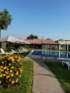 a resort with a swimming pool and some chairs and flowers at Casa vacacional en Manzanillo in Manzanillo