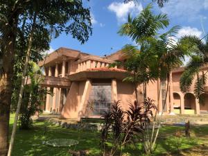 a house with palm trees in front of it at The Twin Grand Apartments in Katunayake