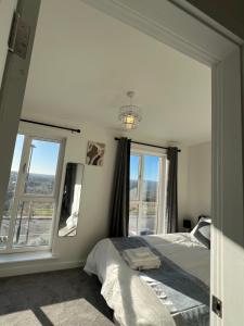 een slaapkamer met een bed en een groot raam bij New Peaceful Luxury Home with free ParkingWiFi Sheffield in Sheffield