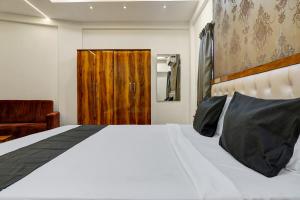 a bedroom with a white bed with a wooden door at OYO KP Pride in Pune