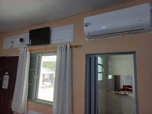 La salle de bains est pourvue d'une fenêtre et de la climatisation. dans l'établissement Comunidade Anuncia-Me, à Guaratinguetá