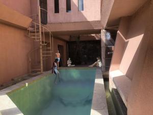 a woman in a swimming pool in a building at The Twin Grand Apartments in Katunayake