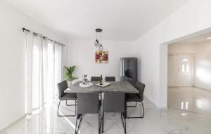 una sala da pranzo bianca con tavolo e sedie di Amazing Apartment In Petrcane With Wifi a Petrcane