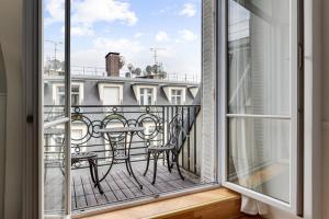 a balcony with a table and chairs and a window at 240 Suite Elysée - Superb apartment in Paris in Paris