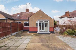 a house with a white door in a yard at Edgware Oasis: Modern Haven near Tube & Park in Edgware