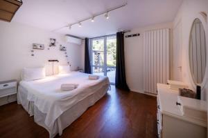 a bedroom with a white bed and a large window at 06V - Beautiful villa with spa pool and tennis in Biot