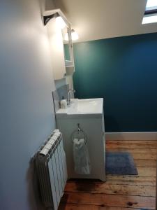 baño con lavabo blanco y pared azul en Thunder Roadhouse, en La Mothe-Saint-Héray