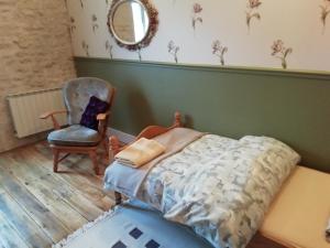 1 dormitorio con cama, silla y espejo en Thunder Roadhouse en La Mothe-Saint-Héray