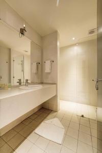 y baño con lavabo, espejo y ducha. en Family Sweet - Apartment in Tala Bay Aqaba, en Al Burj