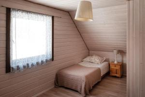 a small bedroom with a bed and a window at Na kwietnej łące - chata w Bieszczadach wysokich in Wetlina +58 photos