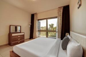 a bedroom with a bed and a large window at Family Sweet - Apartment in Tala Bay Aqaba in Al Burj