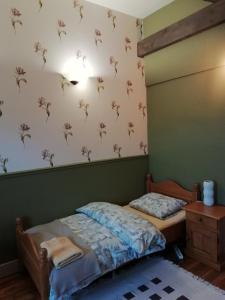 1 dormitorio con 1 cama y una pared con flores en Thunder Roadhouse en La Mothe-Saint-Héray