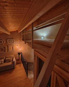 a loft room with two bunk beds and a couch at Cal Cintet in Vilanova de Meyá