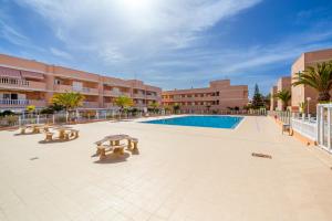 a courtyard with a pool and picnic tables and buildings at Sailor Rest en Costa Sol in Costa Del Silencio