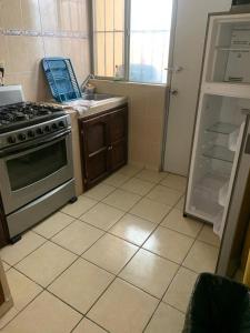 a kitchen with a stove and an open refrigerator at Tu refugio perfecto en Parras in Parras de la Fuente