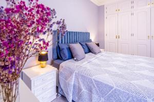 a bedroom with a bed and a vase of purple flowers at Sailor Rest en Costa Sol in Costa Del Silencio +29 photos