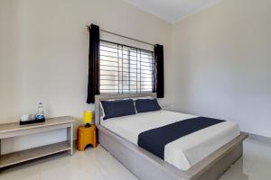 Un dormitorio con una cama grande y una ventana en OYO Power Spirits Boarding and Lodging, en Bangalore