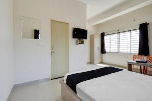 1 dormitorio con 1 cama y TV en la pared en OYO Power Spirits Boarding and Lodging, en Bangalore