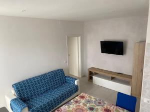 sala de estar con sofá azul y TV en appartamento Nember, en Lido di Jesolo