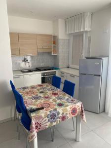 cocina con mesa, sillas y nevera en appartamento Nember, en Lido di Jesolo