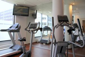 un gimnasio con dos máquinas de correr y una TV en Bastion Hotel Breda, en Breda