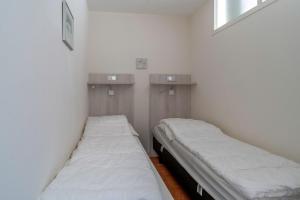 two beds in a room with white walls at Appartementencomplex Juliana 142 in De Koog