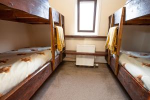 two bunk beds in a room with a window at Glenfeshie Hostel in Insh