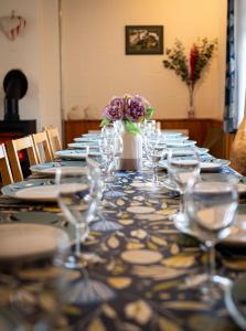 a long table with glasses and a vase of flowers at Glenfeshie Hostel in Insh