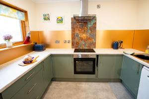 a kitchen with green cabinets and a sink at Glenfeshie Hostel in Insh