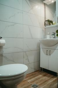 bagno bianco con servizi igienici e lavandino di Tyulev apartment 2 a Varna
