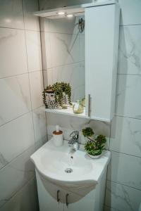 bagno bianco con lavandino e specchio di Tyulev apartment 2 a Varna