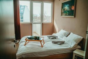 un letto con un vassoio sopra e un tavolo sopra di Tyulev apartment 2 a Varna