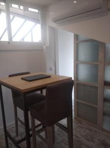 Habitación con mesa, 2 sillas y litera en Atico España, en Las Rozas de Madrid