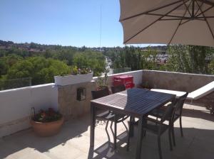 a table and chairs on a balcony with an umbrella at Atico España in Las Rozas de Madrid