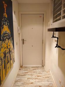 a hallway with a door and a painting on the wall at Atico España in Las Rozas de Madrid