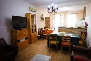 cocina y comedor con mesa y TV en Viv Marmolejo Centro Andujar Cordoba, en Marmolejo