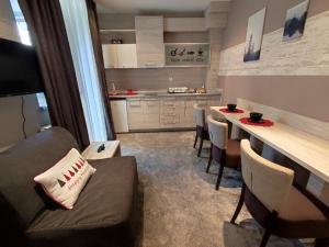 a living room with a couch and a table with chairs at Gondola Studio Brzeće Kopaonik in Brzeće