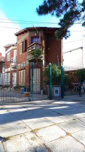 a building with a fence in front of a house at Drumond Paradise in San Bernardo