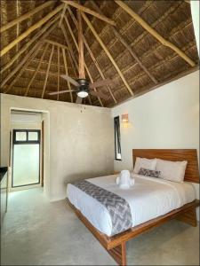 a bedroom with a large bed with a wooden ceiling at The Reserve Tulum in Tulum