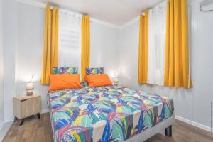 - une chambre avec un lit coloré et des rideaux orange dans l'établissement 971H2 - Cottage "Marie-Galante" with private pool, à Malgré Tout