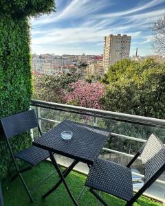 una mesa negra y 2 sillas en el balcón en Private Bedroom with Balcony & Private Bathroom in Modern Shared Apartment - King & Queen size bed, en Vila Nova de Gaia