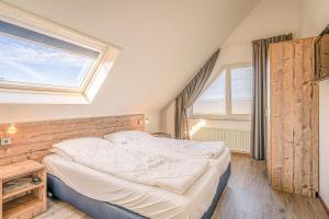 um pequeno quarto com uma cama e uma janela em Villapark Kamperfoelie 71 em De Koog